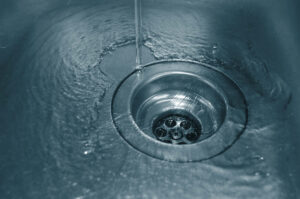 water going down the drain of a kitchen sink