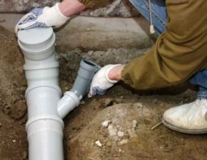 plumber assembling pvc sewer pipe