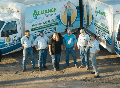 Alliance plumbing team standing in front of service vans
